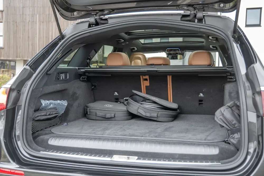 Coffre d'une BMW X5 avec sièges rabattables et intérieur en cuir beige.
