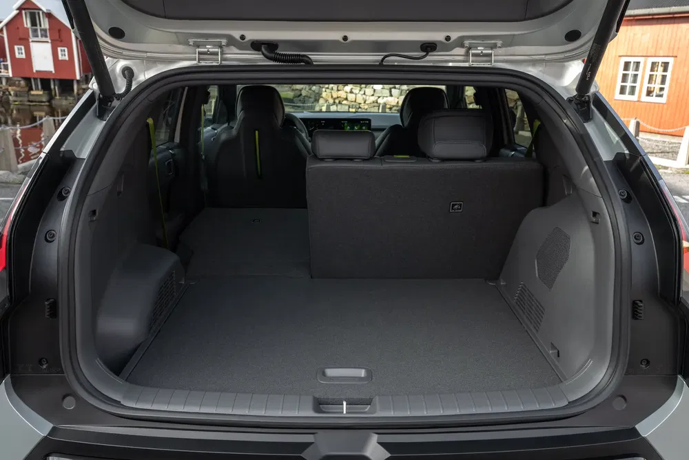 Intérieur spacieux du coffre arrière d'une voiture avec sièges rabattus partiellement, idéal pour le stockage.