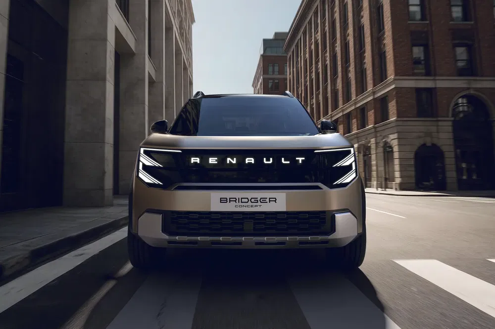 Concept car Renault Bridger dans une rue urbaine avec architecture moderne.