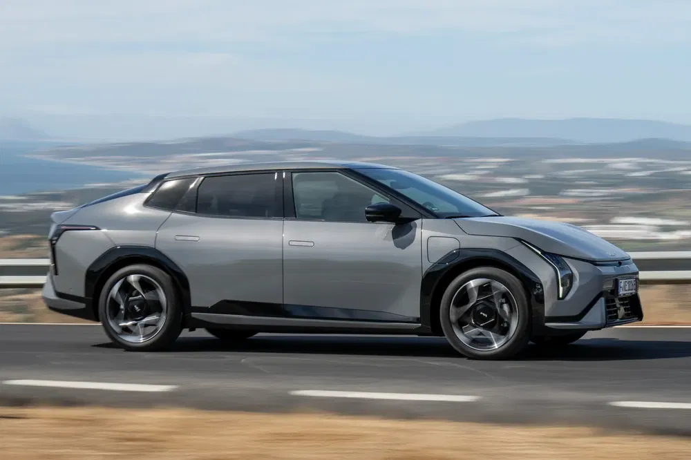 Grijze Citroën ë-C4 X op kustweg, modern en gestroomlijnd ontwerp.