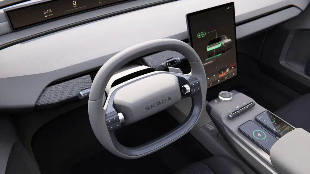 Moderne Škoda-interieur met futuristisch stuur en centraal touchscreen.