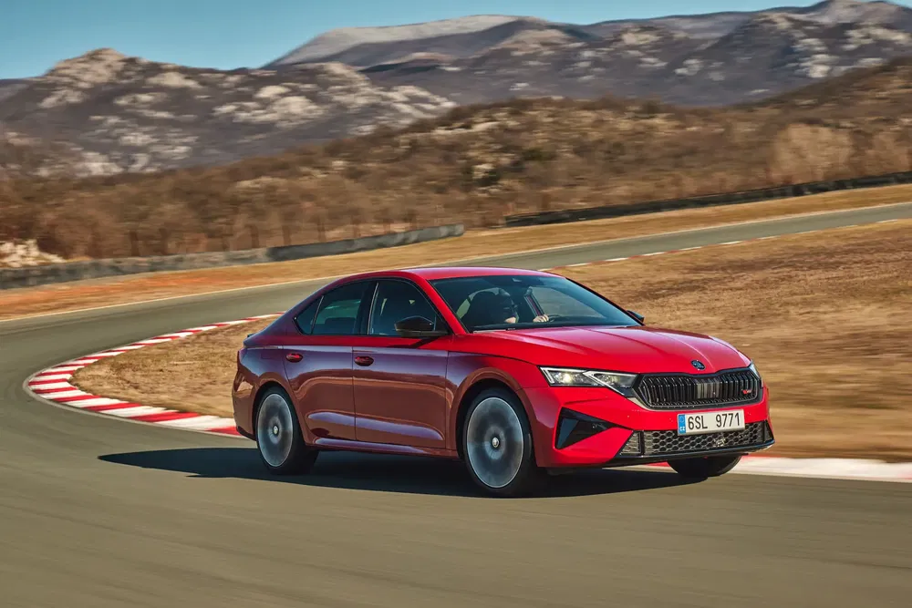 La Skoda Octavia rouge sur une piste sinueuse en montagne, performance et élégance.