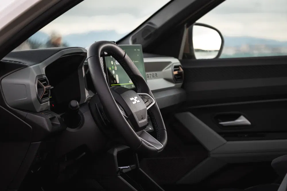 Intérieur moderne du Pickman X avec volant et écran tactile, vue latérale panoramique.