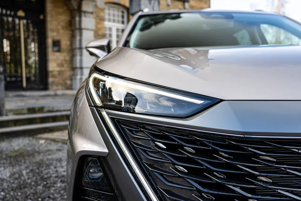 Dichtbij een Peugeot autokoplamp en grille, modern en dynamisch ontwerp.