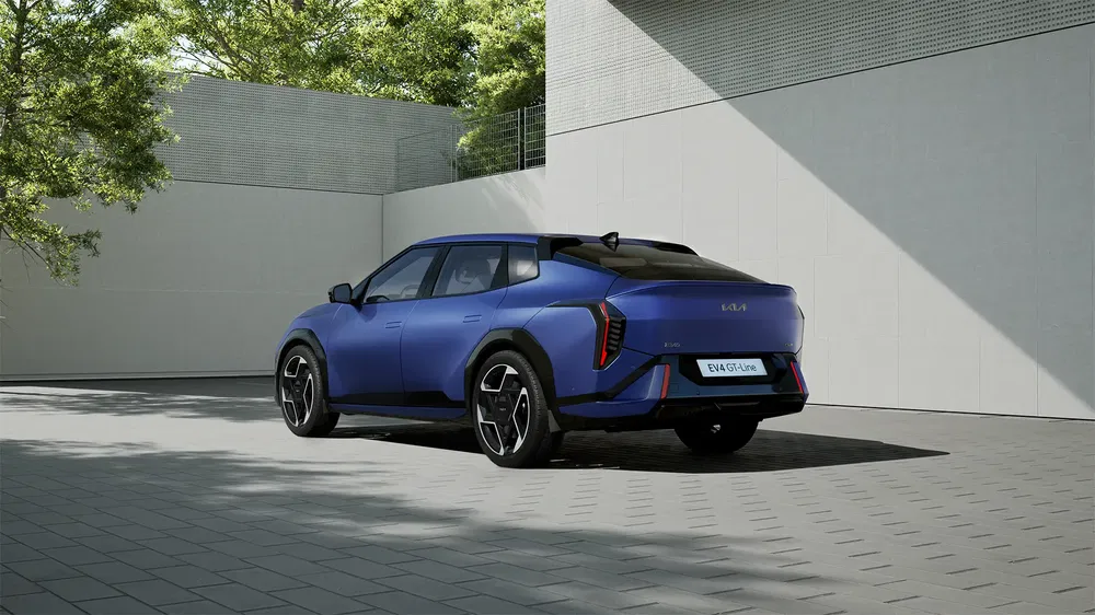 Kia EV9 bleu garé dans une cour moderne, arrière élégant et design futuriste.