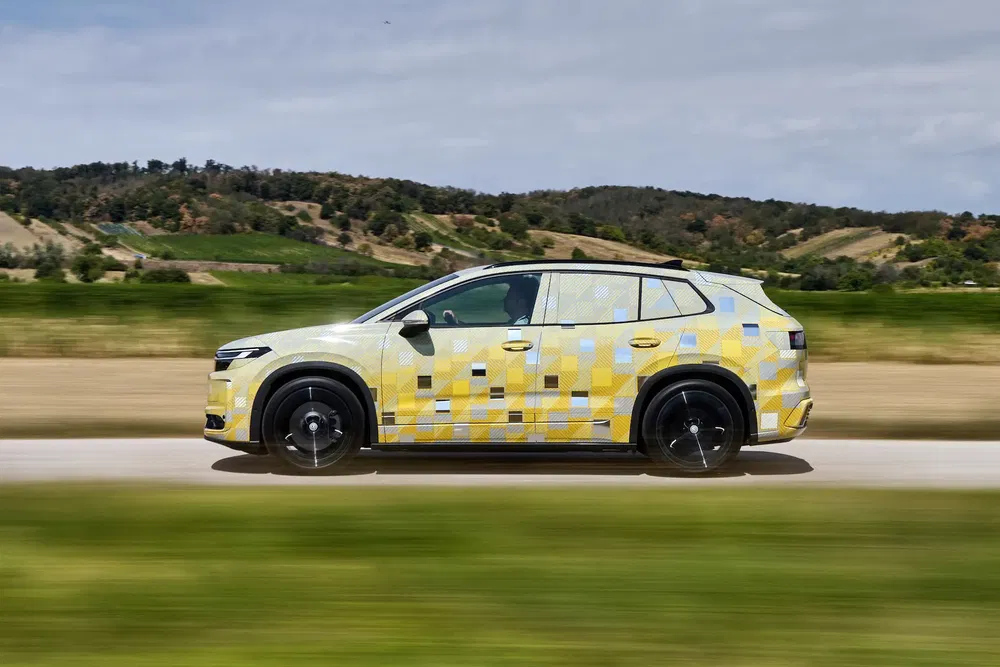 Renault Espace SUV 2024 en test sur route, bicolore jaune et bleu en milieu rural.