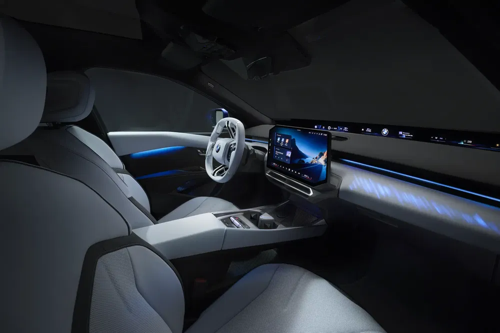 Moderne interieur van een Volkswagen-auto met geavanceerd touchscreen en blauwe sfeerverlichting.