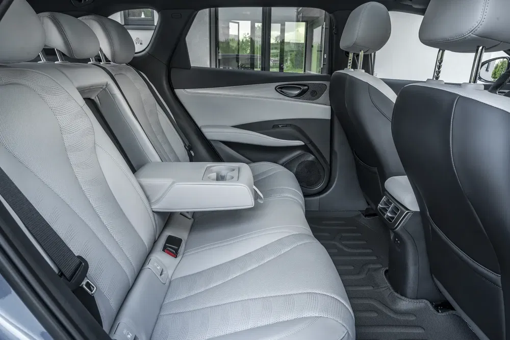 Intérieur arrière élégant d'une voiture avec sièges en cuir gris et accoudoir central.