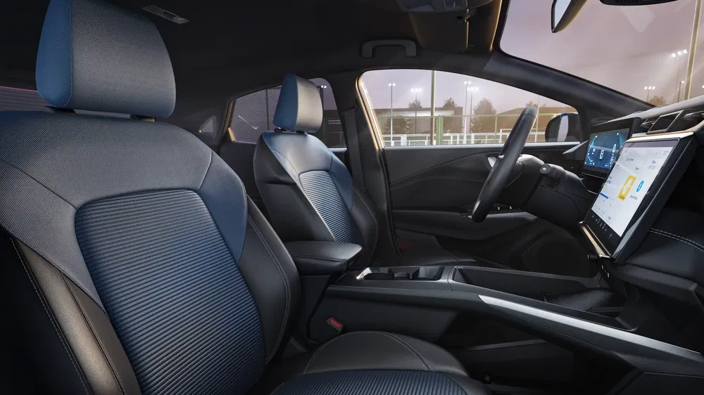 Moderne interieur van een auto met groot aanraakscherm en comfortabele stoelen.