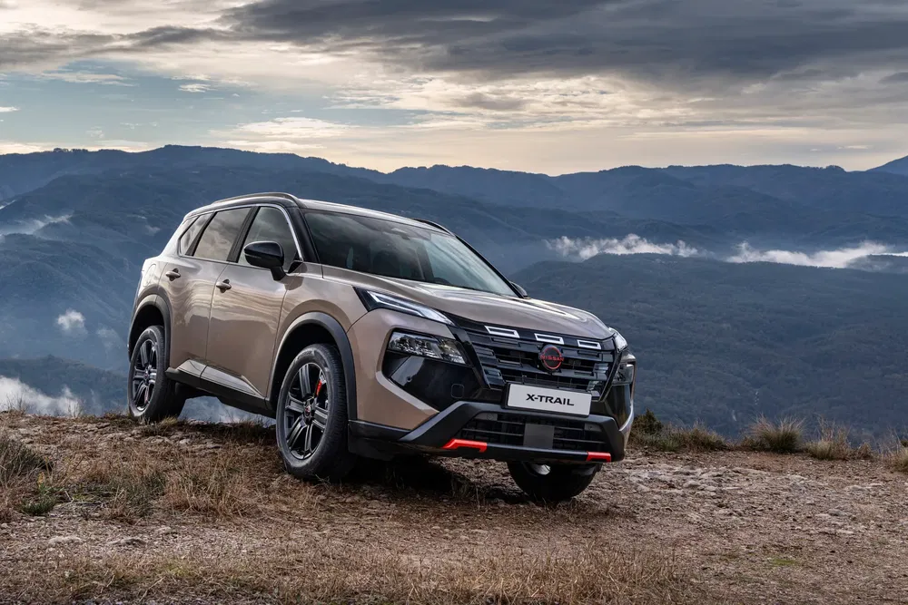 Nissan X-Trail bij zonsondergang op een berg, ideaal voor off-road avonturen.