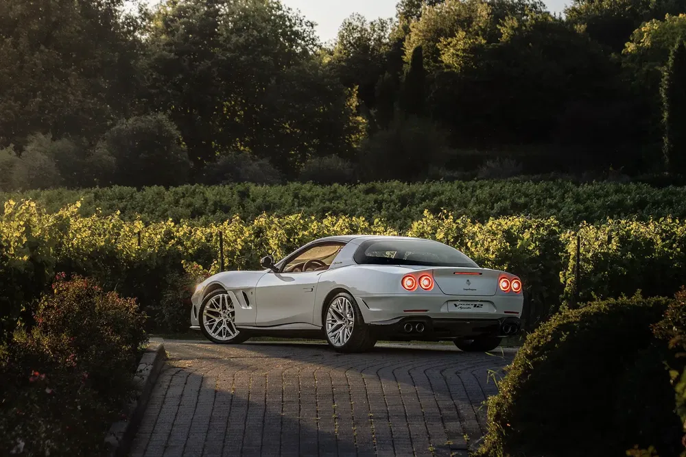 {"fr":"Ferrari moderne argentée garée sur une allée pavée entourée de vignes luxuriantes.","nl":"Moderne zilveren Ferrari geparkeerd op geplaveide oprit omgeven door weelderige wijnstokken."}