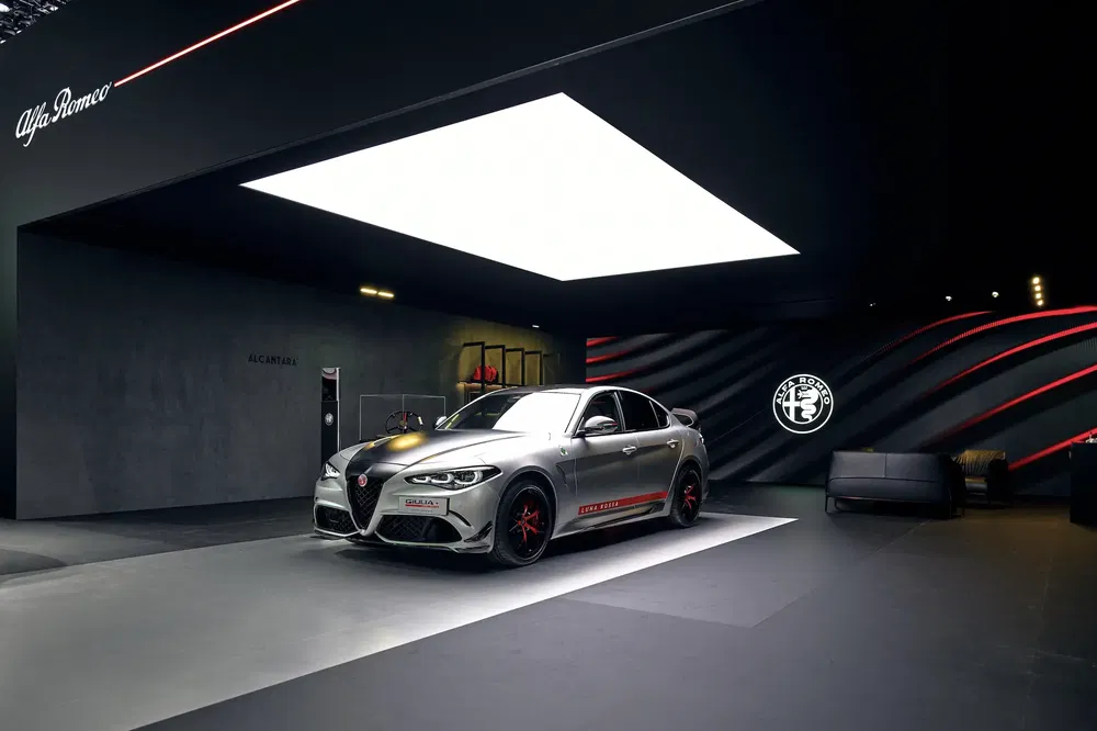 Alfa Romeo Giulia in een stijlvolle showroom met moderne verlichting en strak design.