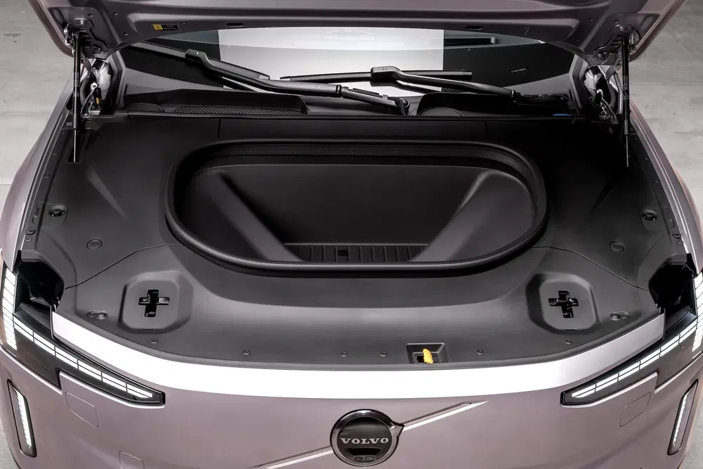 Coffre avant d'une Volvo avec espace de rangement ouvert et logo visible.