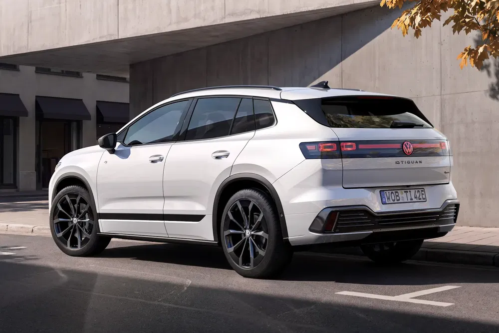 Volkswagen Tiguan blanc, stationné en extérieur, design moderne avec jantes noires élégantes.