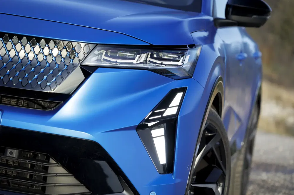 Gros plan sur la calandre et les phares avant du Peugeot 3008 bleu moderne.
