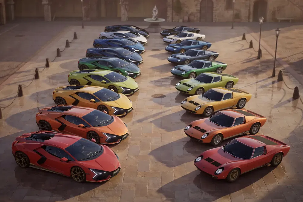 Collection de Lamborghini colorées alignées dans une cour ensoleillée, montrant divers modèles classiques.