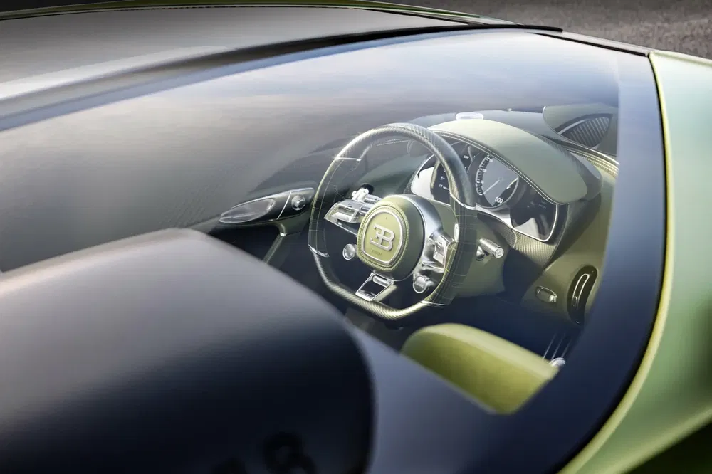 Intérieur de Bugatti Chiron vue à travers le pare-brise, volant en cuir et tableau de bord élégant.