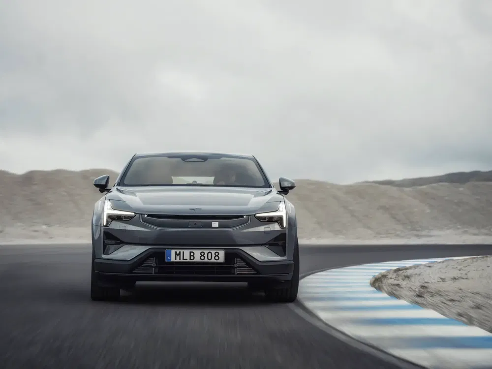 Grijze Polestar 2 op kronkelend circuit, dynamische elektrische prestaties in beweging.