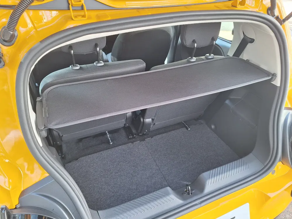 Kofferruimte van gele compacte auto met neerklapbare achterbank voor geoptimaliseerde opbergruimte.