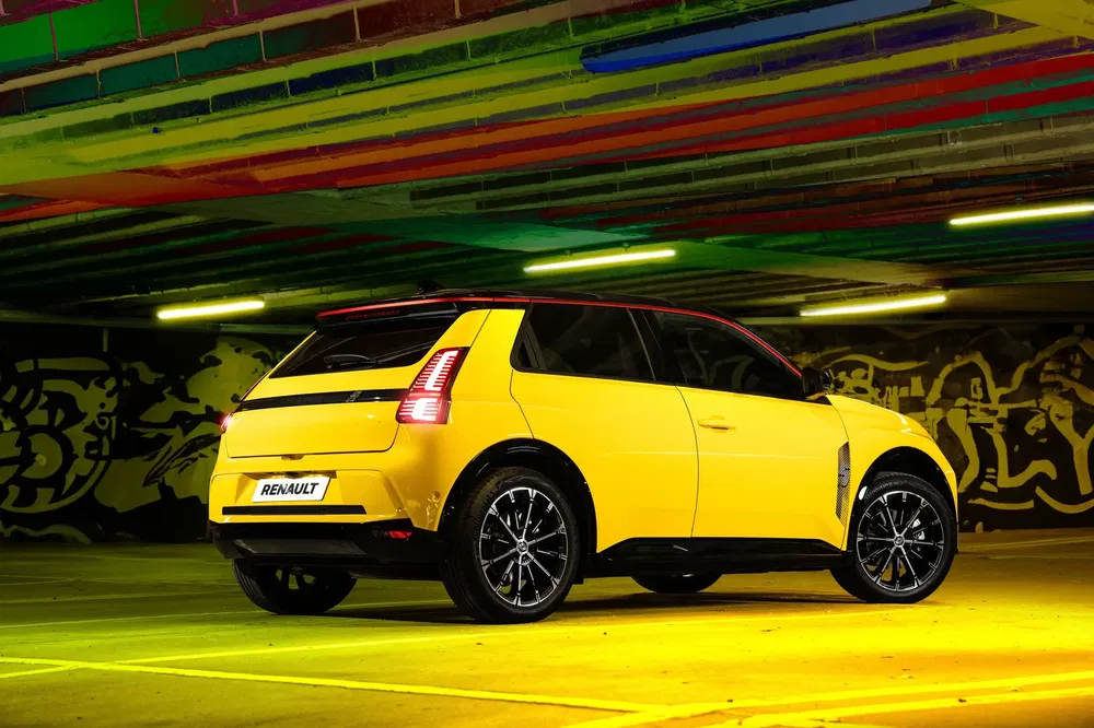 Gele Renault R5 elektrisch in kleurrijke parkeergarage.