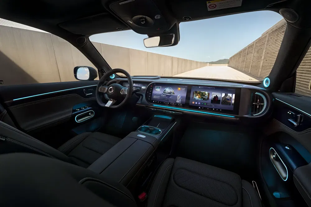Modern auto-interieur met panoramisch digitaal dashboard en sfeerverlichting.