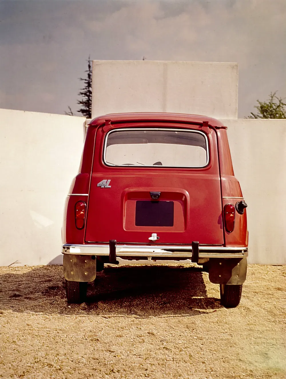 Achteraanzicht van een rode Renault 4L, iconische compacte Franse auto uit de jaren '60.
