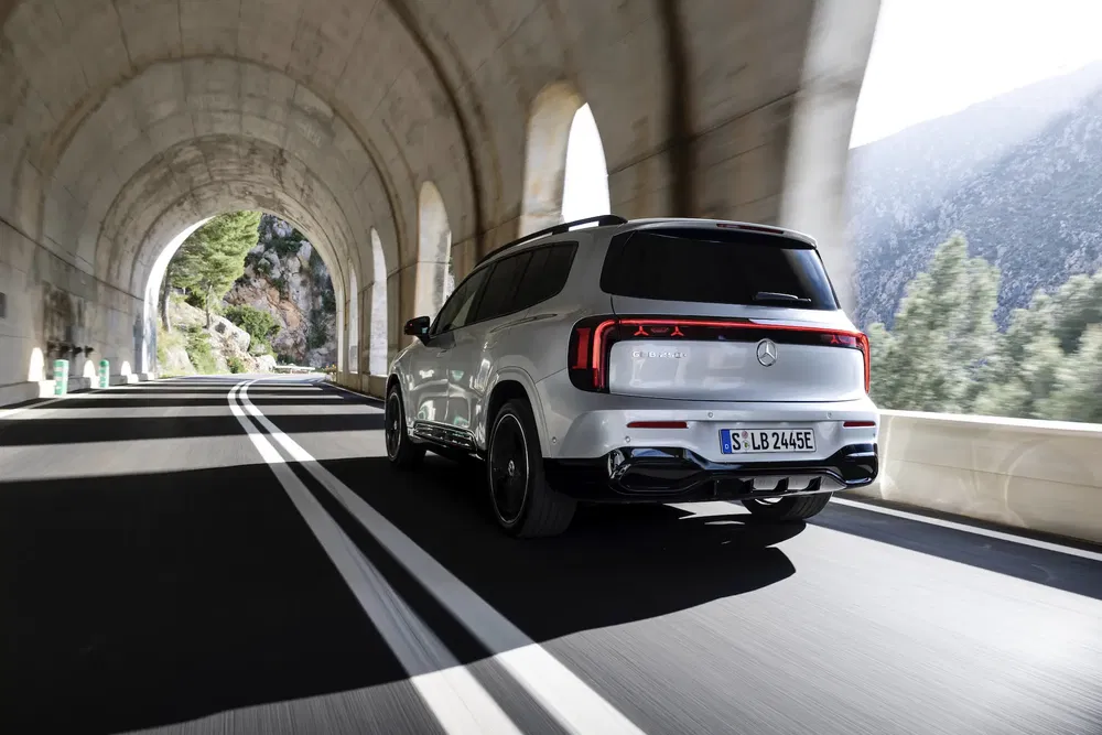 SUV Mercedes-Benz EQB blanc traversant un tunnel panoramique en montagne.
