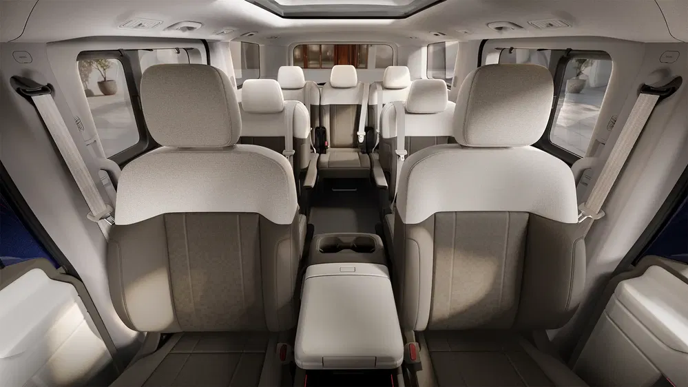 Intérieur spacieux d'un minivan moderne avec sièges en cuir beige et toit panoramique.