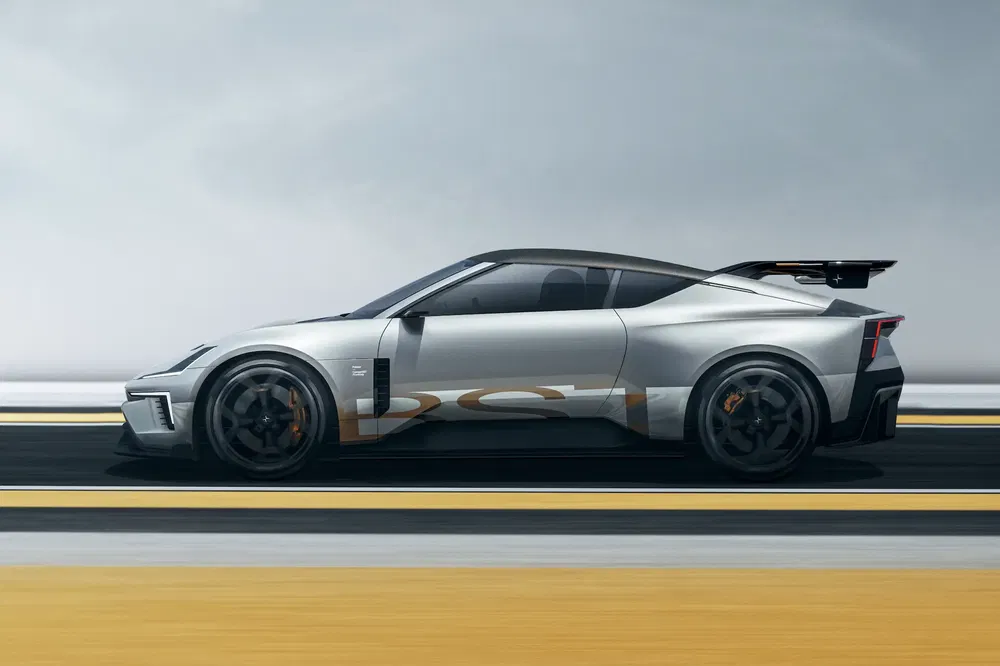 Voiture sportive grise, style moderne, aileron arrière imposant, jantes noires sur piste.