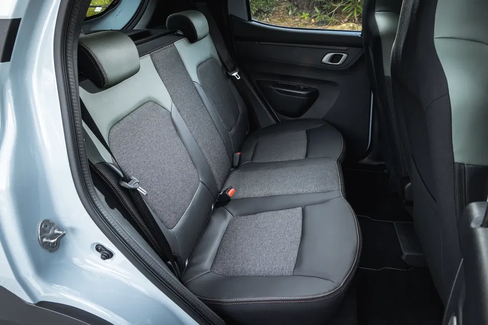 Auto-interieur met achterbank in grijs leer en stof, ruime compacte auto.
