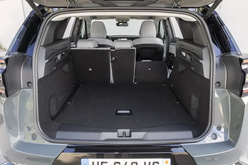 Coffre de voiture Peugeot, spacieux et modulable, avec sièges arrière partiellement rabattus.