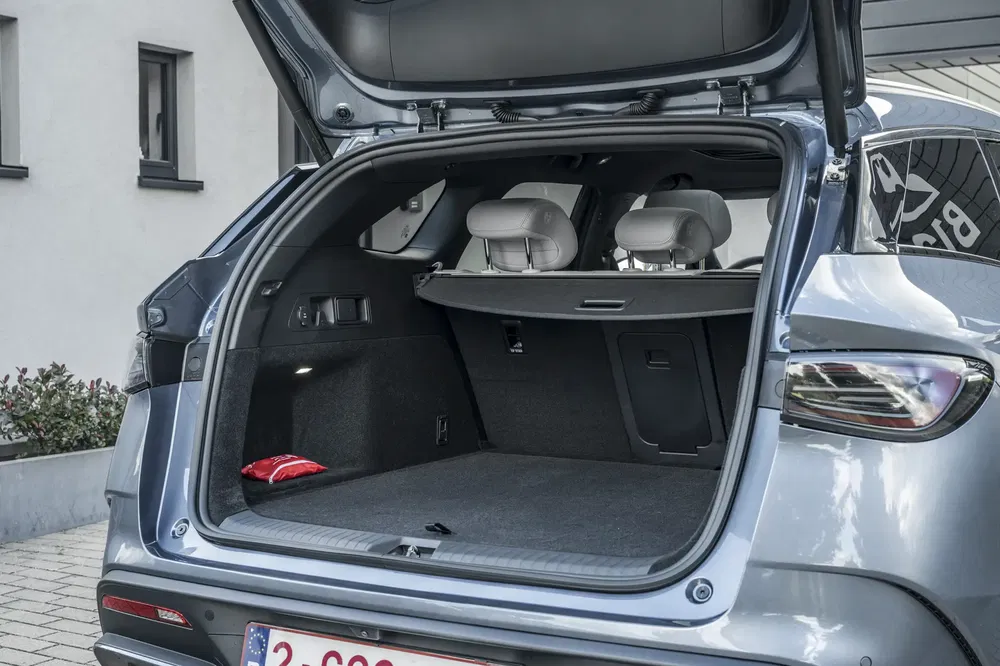 Coffre ouvert d'un SUV moderne avec vaste espace de chargement et sièges arrière visibles.