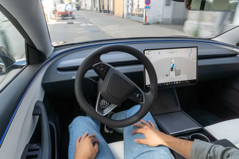 Intérieur d'une voiture autonome avec écran de navigation moderne et tableau de bord minimaliste.