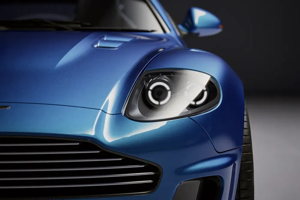 Vue rapprochée d'une voiture de sport bleue, mettant en valeur le phare avant et la carrosserie.