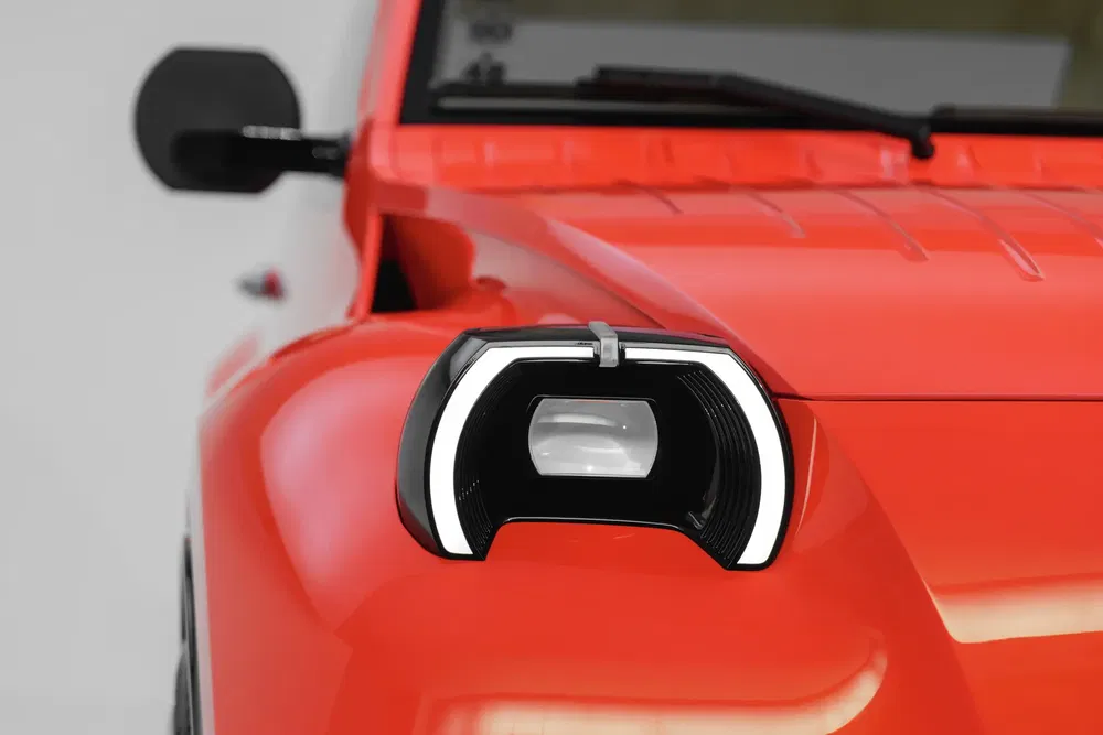 Phare LED moderne sur une voiture rouge, design avant innovant et compact.