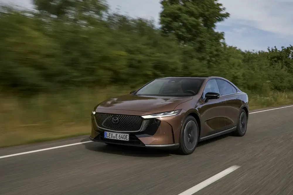 Bruine Mazda-auto op landelijke weg, met slank en gestroomlijnd ontwerp.