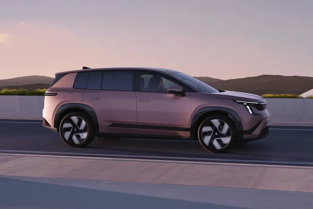 SUV électrique en mouvement sur une route, design moderne et élégant, au coucher du soleil.