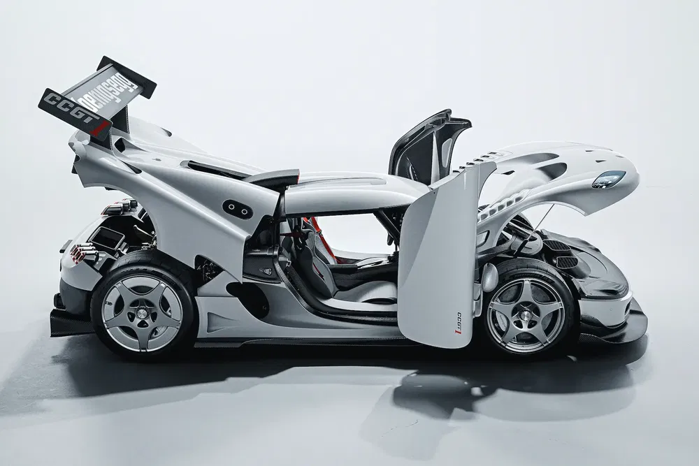 Voiture de sport Koenigsegg CC GT avec portes et capot ouverts, design aérodynamique élégant.