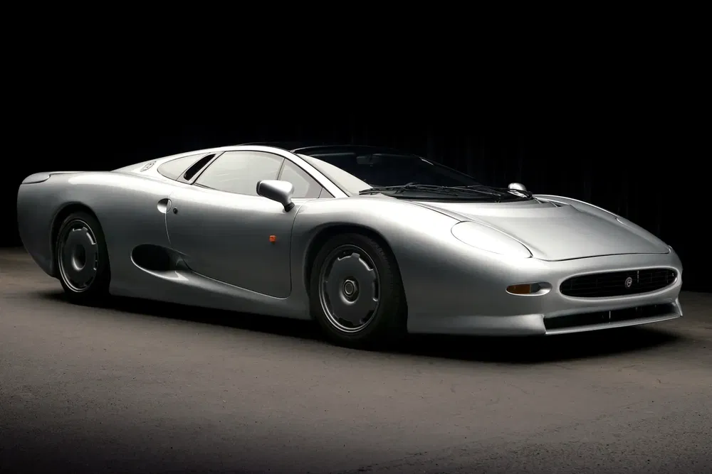 {"fr":"Jaguar XJ220 argent sur fond sombre, design aérodynamique et élégant du supercar emblématique.","nl":"Zilverkleurige Jaguar XJ220 op donkere achtergrond, kenmerkend gestroomlijnd ontwerp van iconische supercar."}