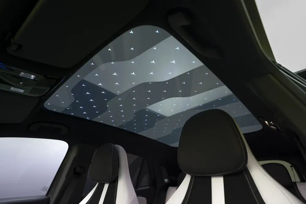 Intérieur de voiture moderne avec toit panoramique en verre illuminé dans un SUV électrique.