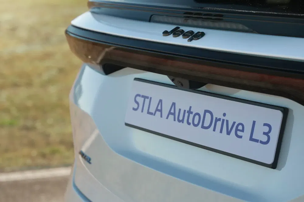 Achteraanzicht van Jeep met STLA AutoDrive L3 plaat op weg.