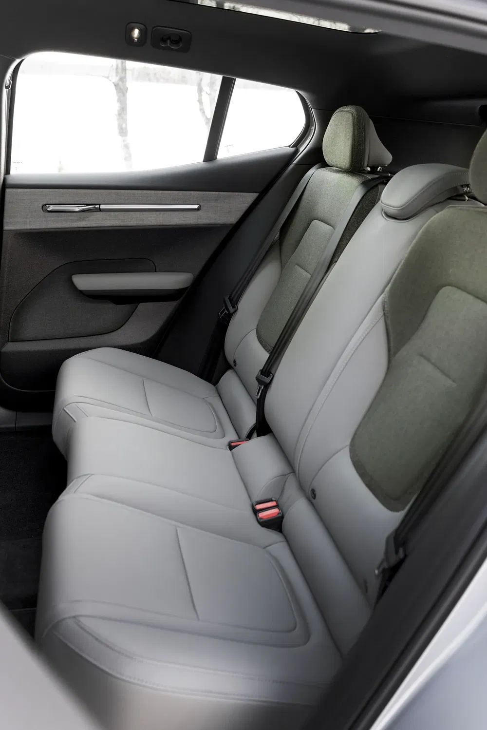 Intérieur arrière moderne d'une voiture électrique Polestar avec sièges confortables en cuir gris.