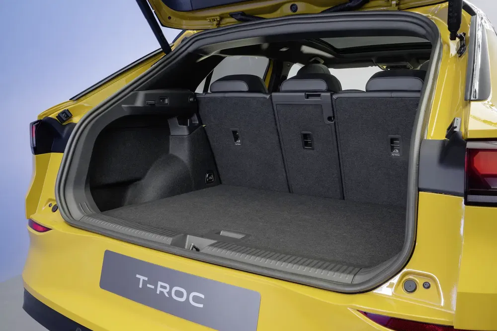 Coffre spacieux du Volkswagen T-Roc jaune, banquette arrière rabattable.