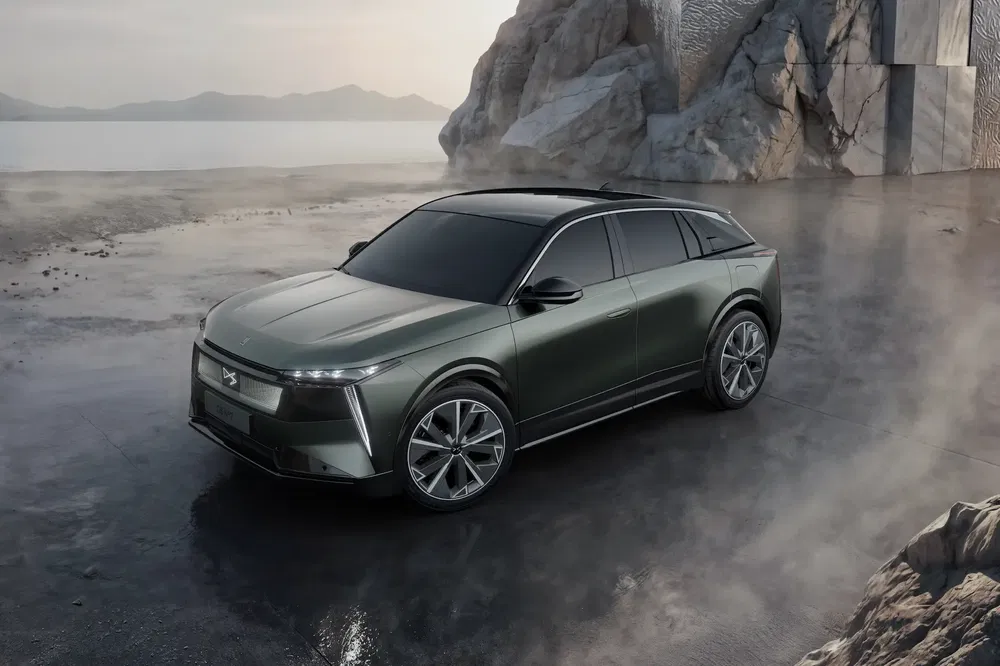Moderne SUV op rotsachtig en mistig landschap, donker metallic groene kleur.