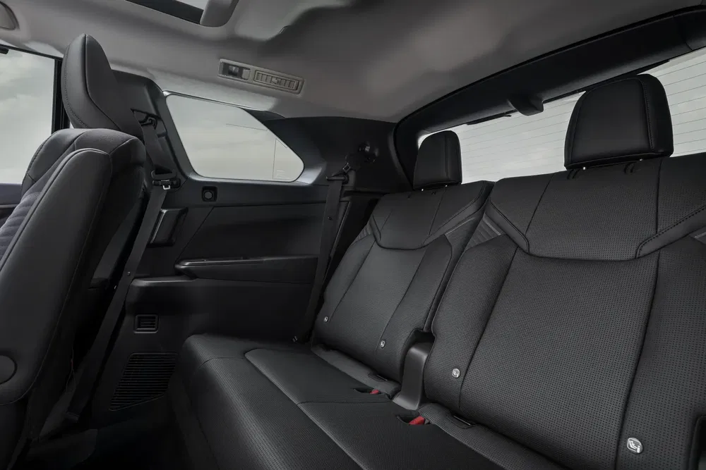 Intérieur d'un SUV moderne avec sièges arrière en cuir noir et toit panoramique.