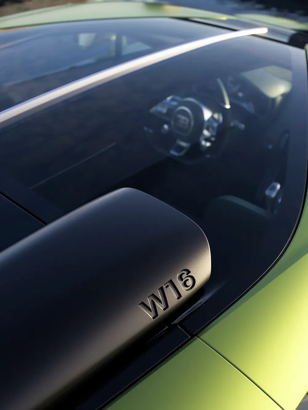 Bugatti Chiron, moteur W16 visible, vue intérieure et extérieure en arrière-plan.