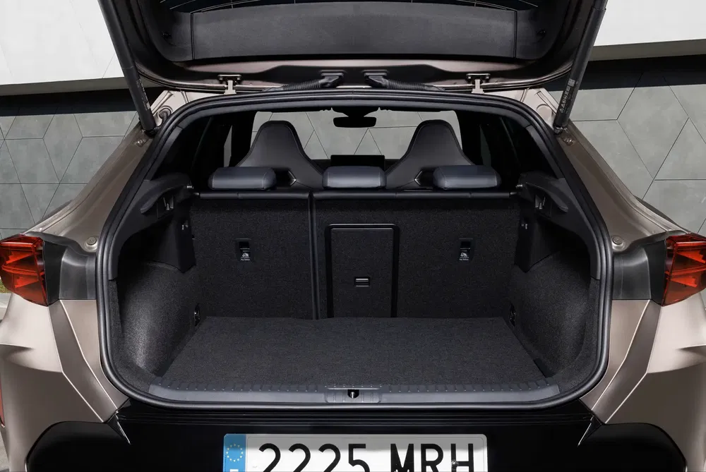 Coffre de voiture ouvert avec sièges arrière rabattables, numéro de plaque 2225 MRH.