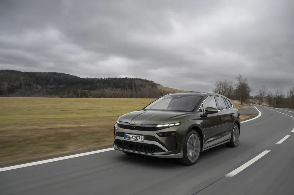 SUV Aiways U6 roulant sur une route de campagne sous un ciel nuageux.