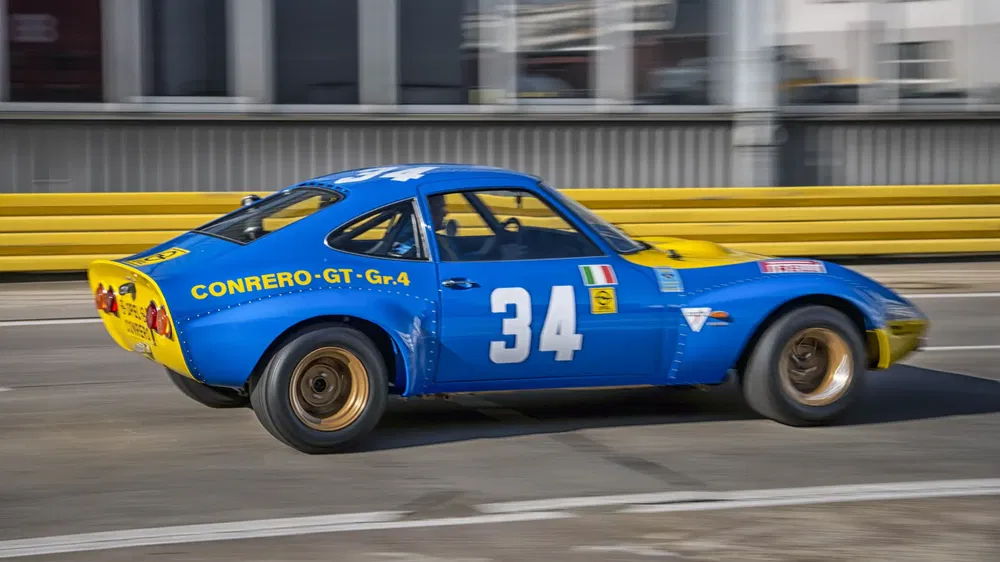 Opel GT Conrero racewagen blauw en geel met nummer 34 op het circuit.