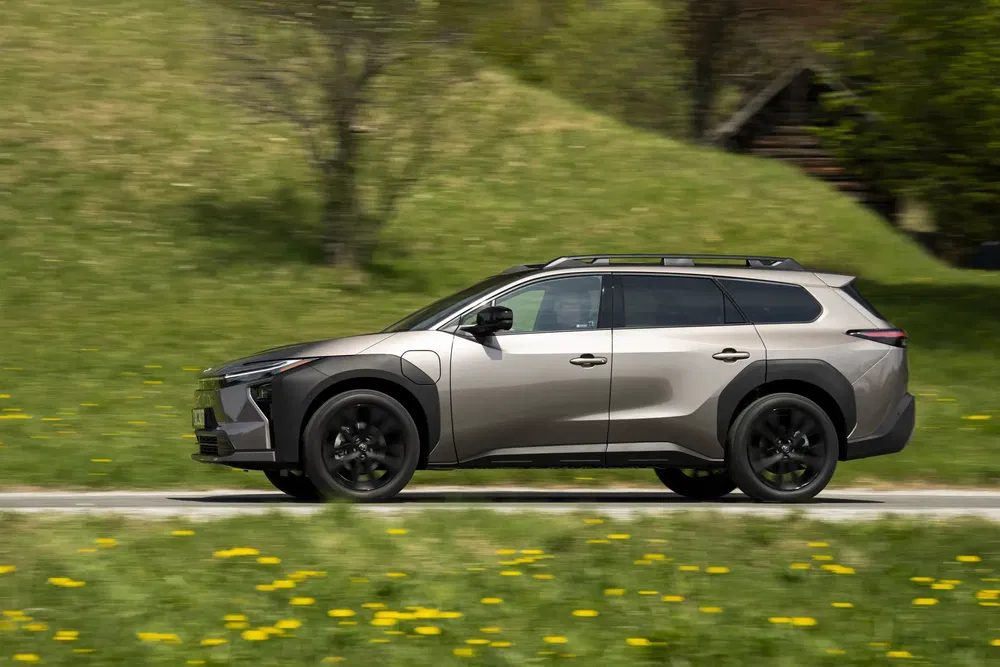 Toyota bZ4X 2023 roulant à travers un paysage verdoyant et fleuri.